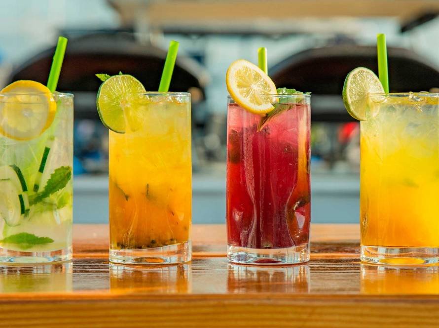 A vibrant array of alcohol-free mocktails with fresh garnishes is served at a wedding reception.